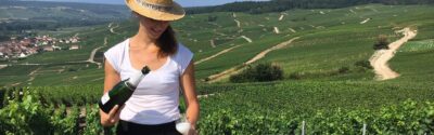 Photo d'une femme servant du champagne au milieu des vignes